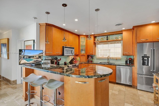 kitchen with decorative light fixtures, tasteful backsplash, sink, dark stone counters, and stainless steel appliances