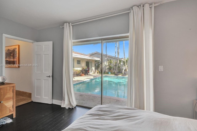 bedroom featuring access to exterior and dark hardwood / wood-style flooring