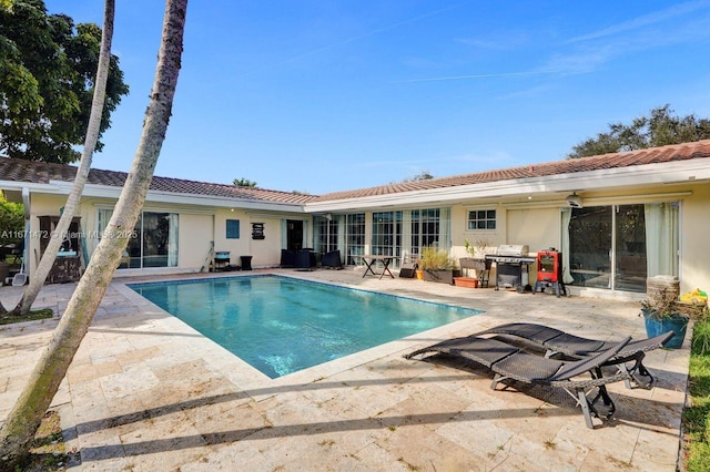 view of swimming pool with grilling area and a patio