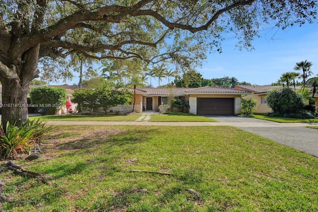 ranch-style home featuring a garage and a front lawn