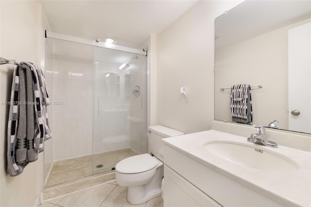 bathroom with vanity, toilet, tile patterned floors, and a shower with door