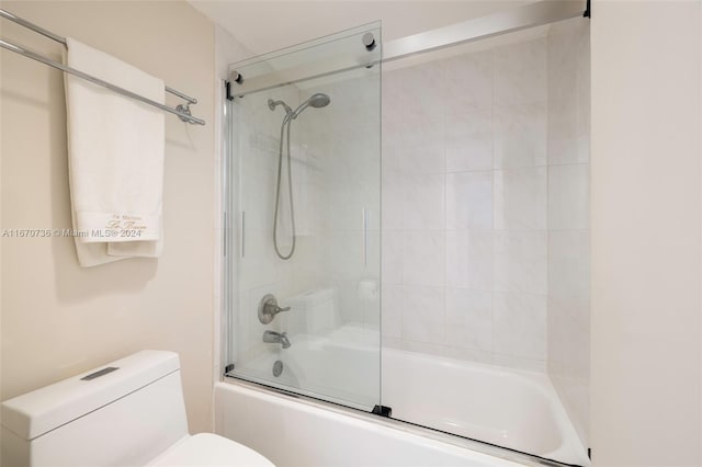 bathroom with shower / bath combination with glass door and toilet