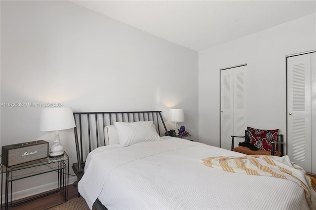 bedroom with hardwood / wood-style floors and multiple closets