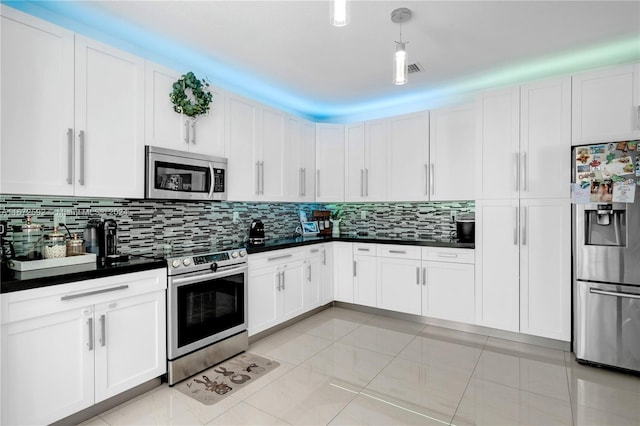 kitchen featuring appliances with stainless steel finishes, backsplash, light tile patterned flooring, and white cabinetry