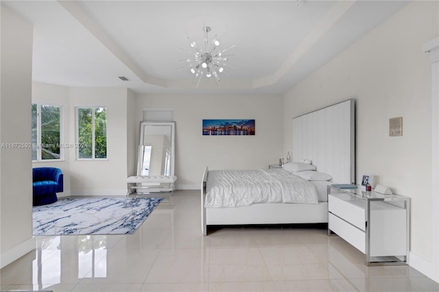 bedroom with a tray ceiling and a chandelier