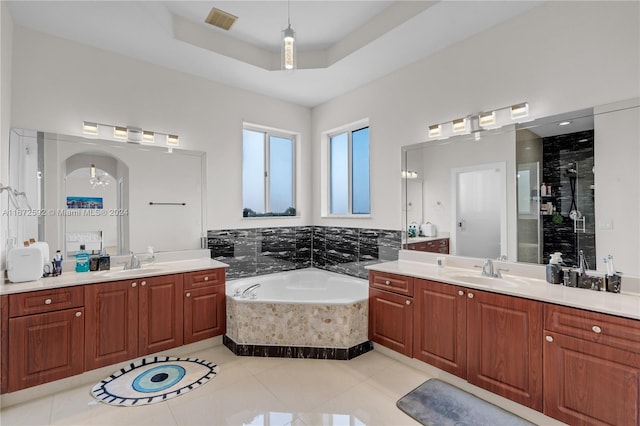 bathroom featuring shower with separate bathtub, tile patterned flooring, a raised ceiling, and vanity