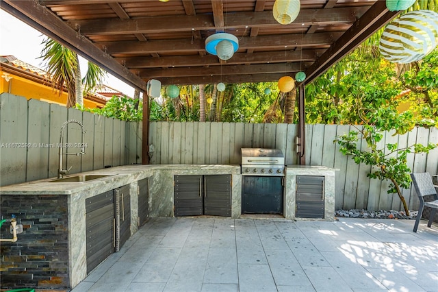 view of patio with an outdoor kitchen, a grill, and sink