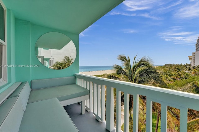 balcony featuring a view of the beach and a water view