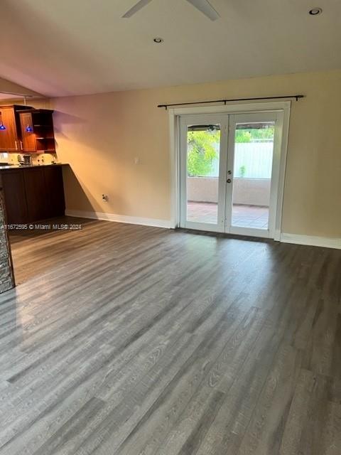 unfurnished living room featuring vaulted ceiling, ceiling fan, hardwood / wood-style flooring, and french doors