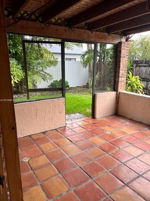 unfurnished sunroom with wood ceiling and beam ceiling