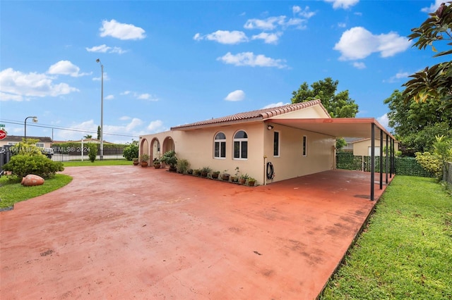 view of side of home with a carport and a yard