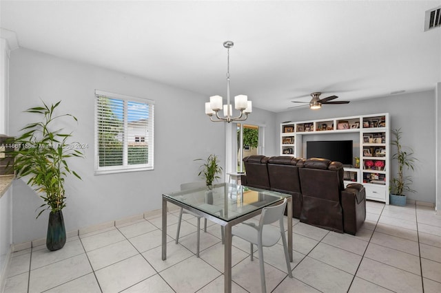 tiled dining room featuring ceiling fan with notable chandelier