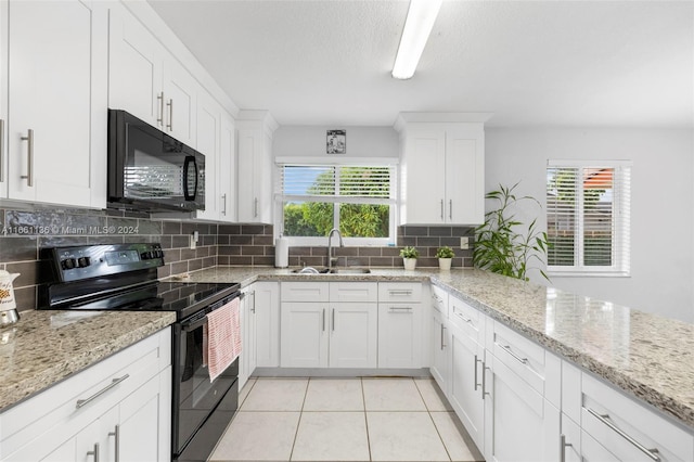 kitchen with a healthy amount of sunlight, black appliances, sink, and white cabinets