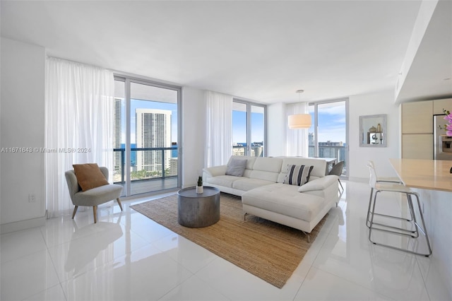 living room with a wall of windows, a healthy amount of sunlight, and light tile patterned floors