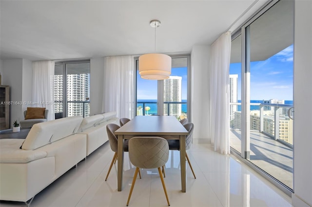 tiled dining room with a water view and a wall of windows