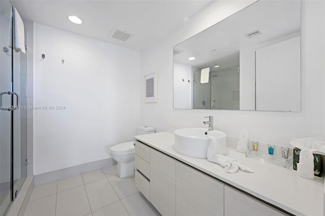 bathroom with vanity, toilet, an enclosed shower, and tile patterned floors