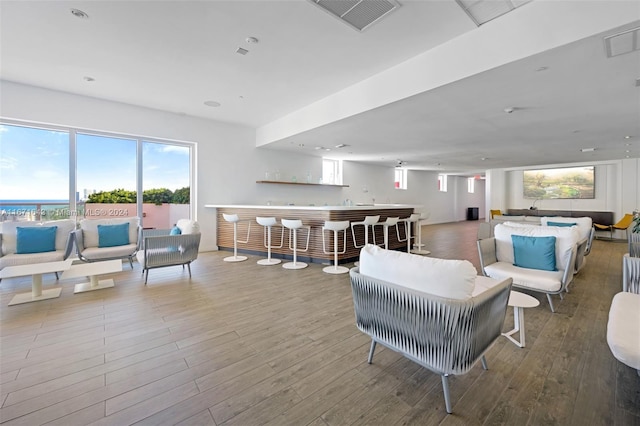 living room with bar area and hardwood / wood-style flooring