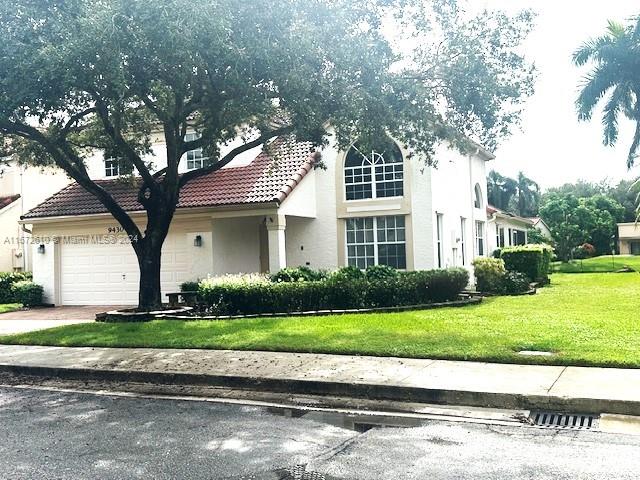 view of front facade with a garage and a front lawn