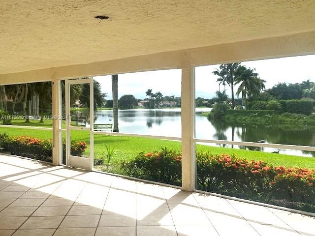 unfurnished sunroom featuring a water view