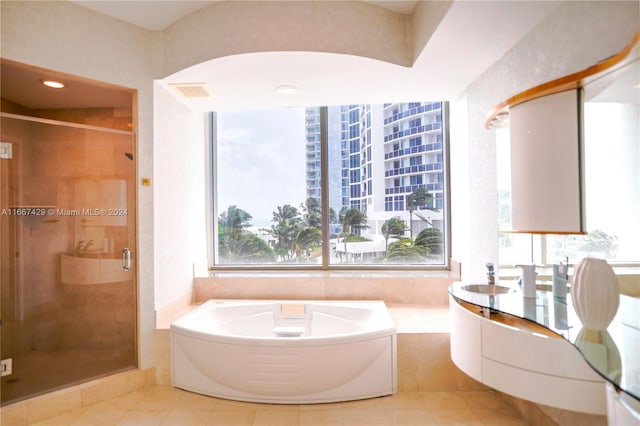 bathroom with plus walk in shower, tile patterned flooring, and vanity