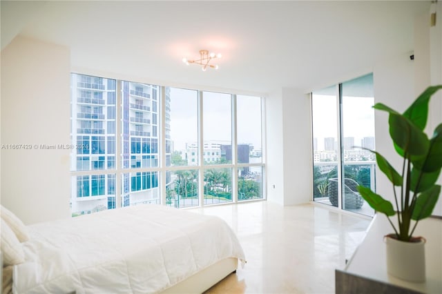 bedroom featuring a notable chandelier, floor to ceiling windows, and multiple windows