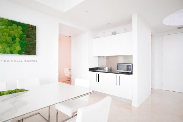 kitchen with a breakfast bar, sink, and white cabinets