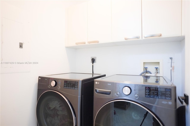 laundry area with washer and clothes dryer and cabinets