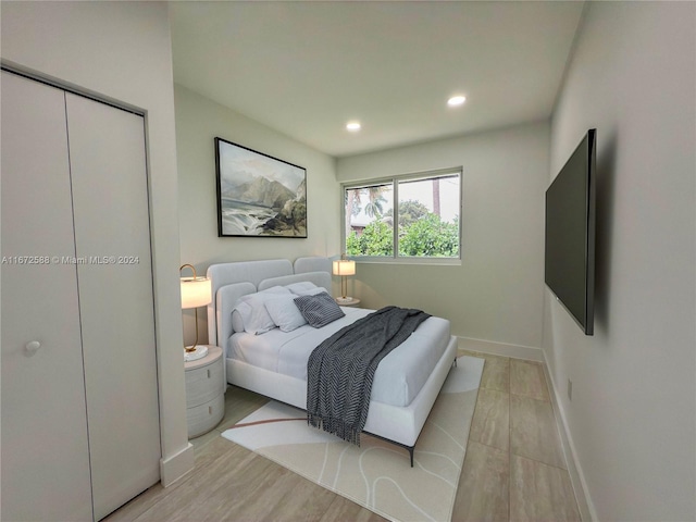 bedroom with light hardwood / wood-style flooring and a closet