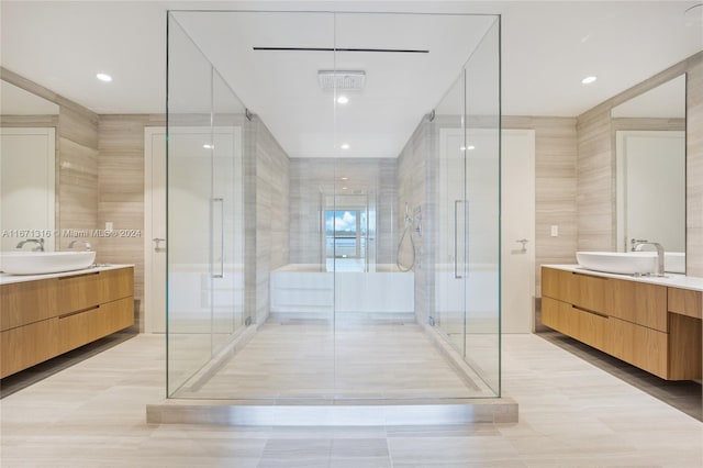 bathroom featuring vanity, tile walls, and a shower with door