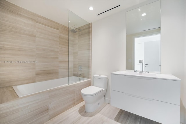 full bathroom with tiled shower / bath combo, vanity, toilet, and hardwood / wood-style flooring