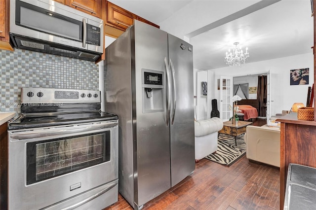 kitchen featuring an inviting chandelier, dark hardwood / wood-style flooring, stainless steel appliances, and tasteful backsplash