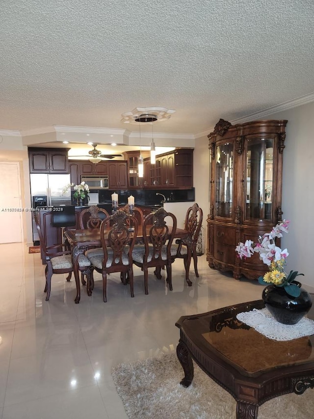 dining area with a textured ceiling and crown molding