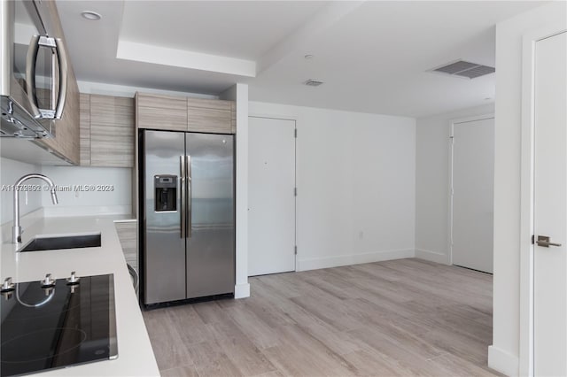 121 NE 34th St Unit 2806A, Miami, FL 33137 - kitchen featuring light countertops, visible vents, a sink, light wood-style flooring, and appliances with stainless steel finishes