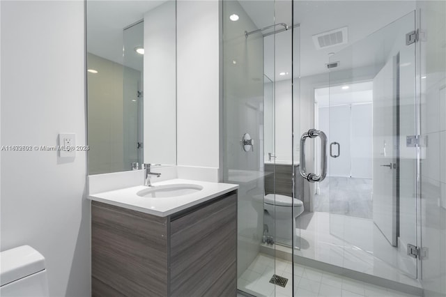 bathroom with vanity, a shower with shower door, toilet, and tile patterned floors