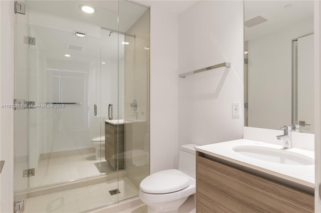 bathroom featuring vanity, a shower with shower door, toilet, and tile patterned floors