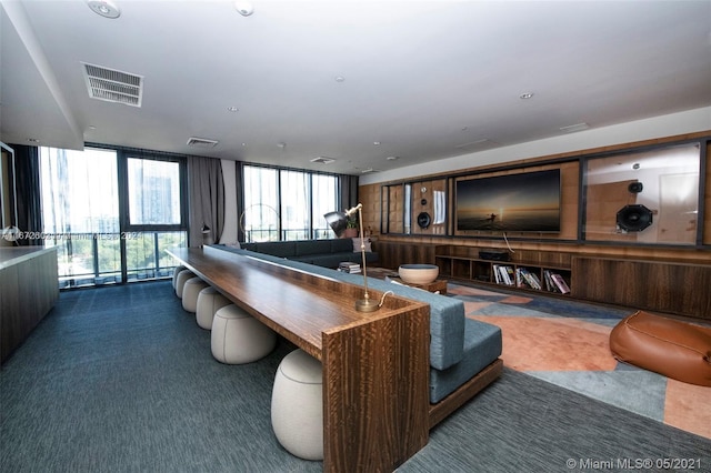 recreation room with floor to ceiling windows and dark colored carpet