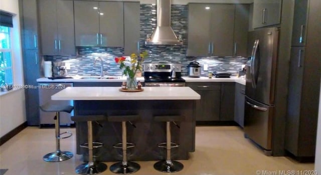 kitchen with a breakfast bar, appliances with stainless steel finishes, sink, and ventilation hood