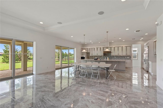 kitchen with decorative backsplash, a wealth of natural light, a spacious island, and crown molding