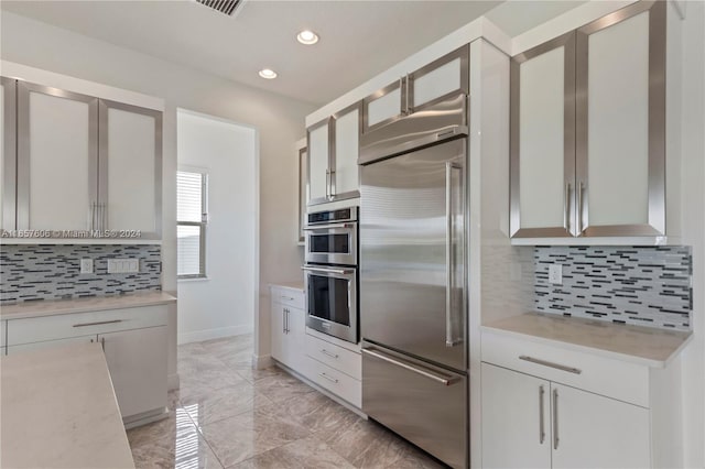 kitchen with appliances with stainless steel finishes and tasteful backsplash