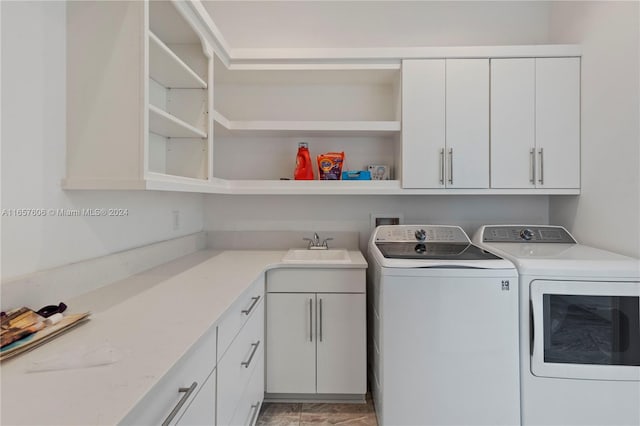 washroom featuring cabinets, sink, and washing machine and clothes dryer