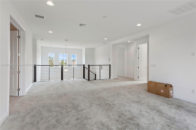 carpeted empty room with a chandelier