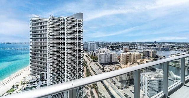 balcony featuring a view of the beach and a water view