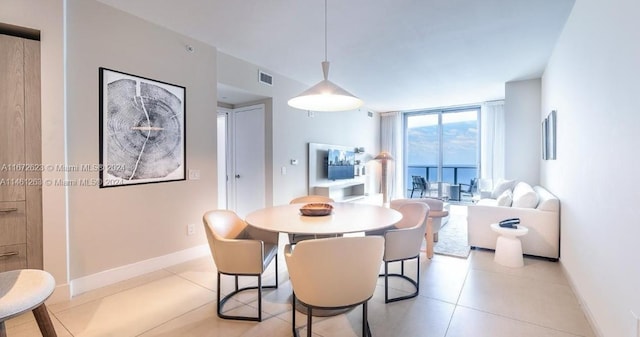 dining area with floor to ceiling windows and light tile patterned floors