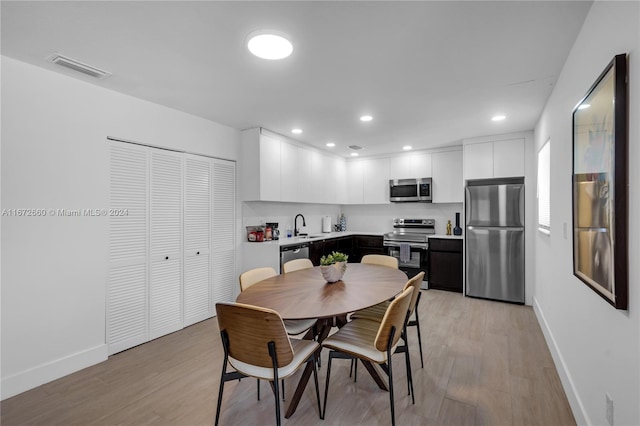 dining area featuring sink and light hardwood / wood-style floors