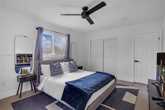 bedroom with ceiling fan, light wood-type flooring, and a closet