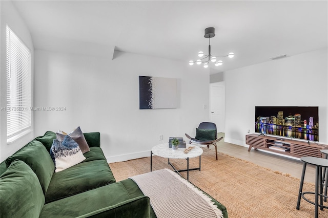 living room with an inviting chandelier and hardwood / wood-style flooring