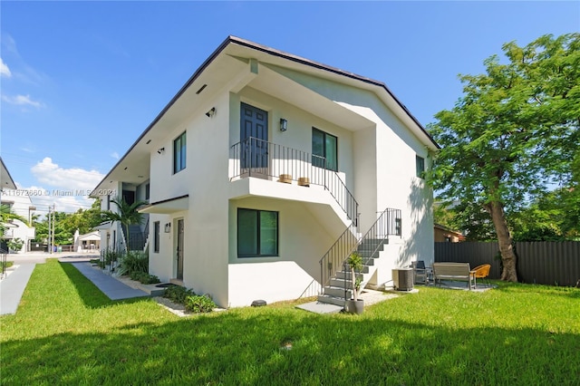 rear view of house featuring a lawn, a patio, and central air condition unit