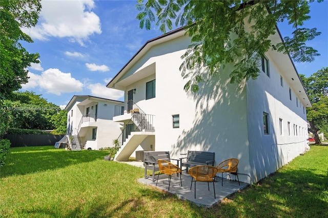 rear view of house featuring a patio and a yard