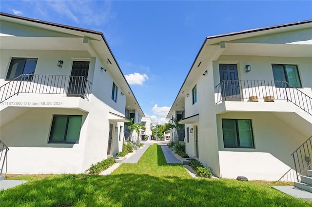 view of home's exterior with a lawn and a balcony