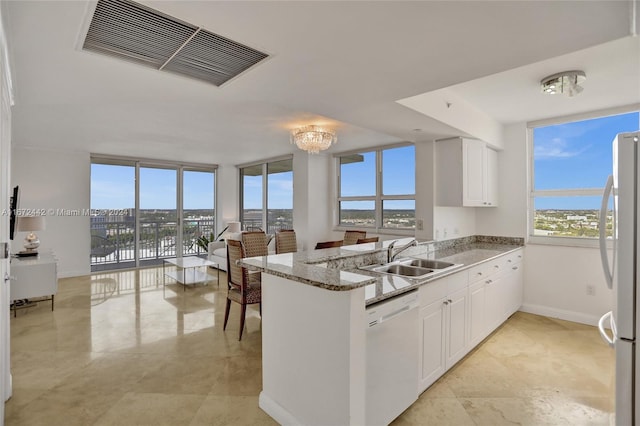 kitchen featuring kitchen peninsula, white dishwasher, white cabinetry, and sink